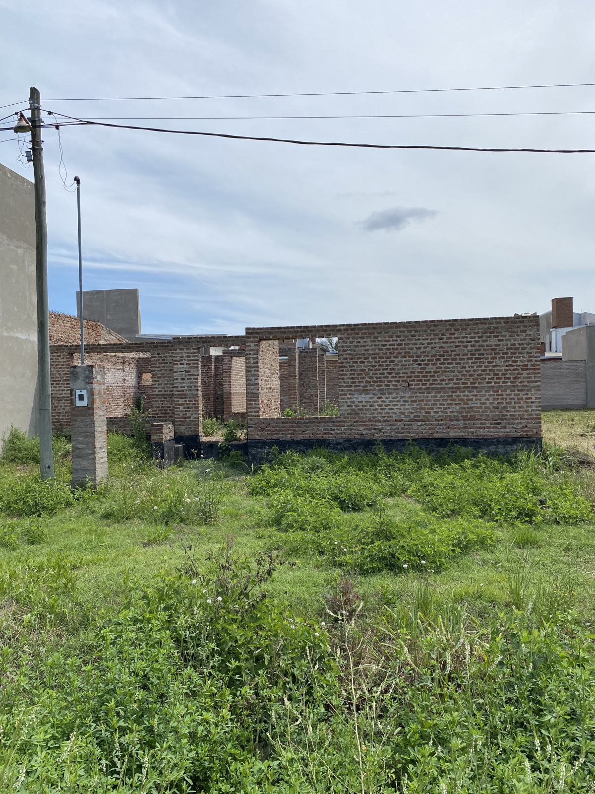Importante terreno con desarrollo de obra, paredes levantadas hasta la altura del dintel. Muy buen entorno y accesible por su cercanía a la Av Aristobulo del Valle.