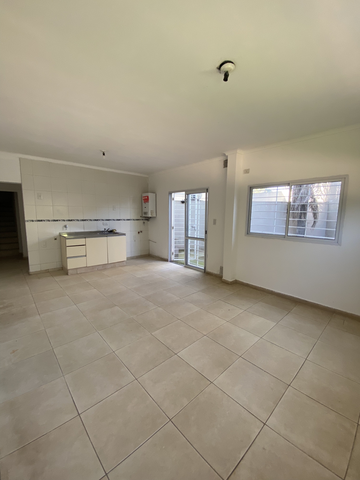 Moderno y funcional dúplex desarrollado en planta baja, ideal para quienes buscan comodidad y buena ubicación. Al ingresar, te recibe un amplio living comedor con cocina integrada, que se conecta directamente con el patio y el espacio de cochera, brindando una excelente circulación y aprovechamiento de los espacios. La planta baja cuenta además con un baño completo y un práctico sector de guardado bajo escalera. En la planta alta, se encuentran dos dormitorios luminosos y un segundo baño completo. Toda la propiedad se destaca por su excelente iluminación natural y distribución eficiente.